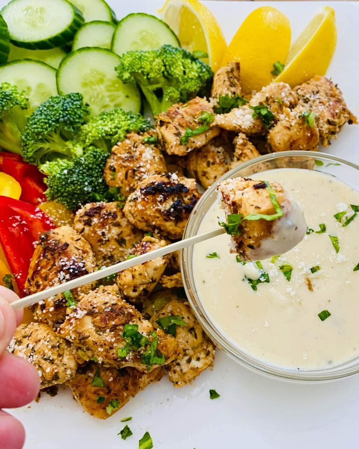 appetizer with sauteed poultry, veggies and dip.