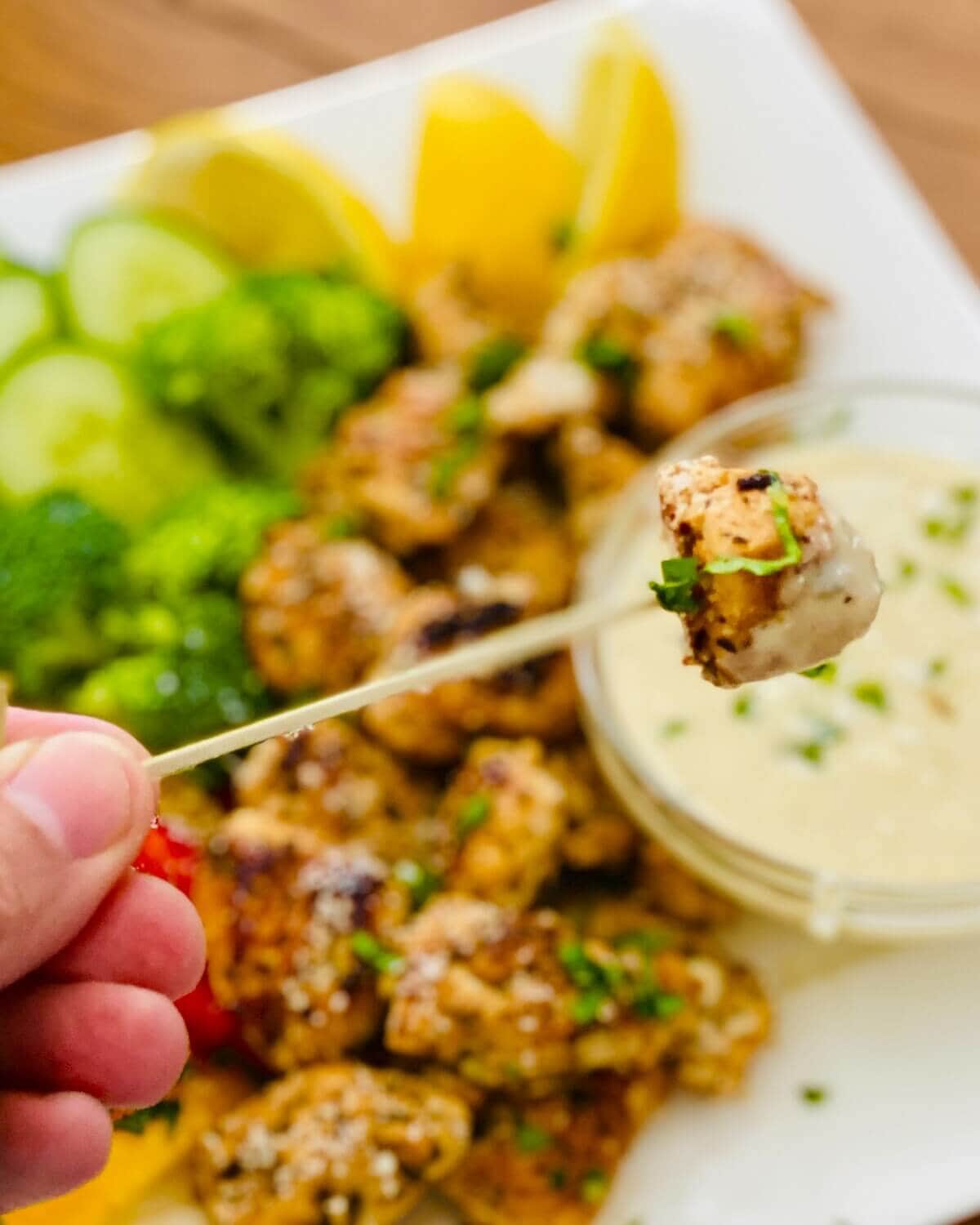 dipping chicken in Caesar dressing dip.