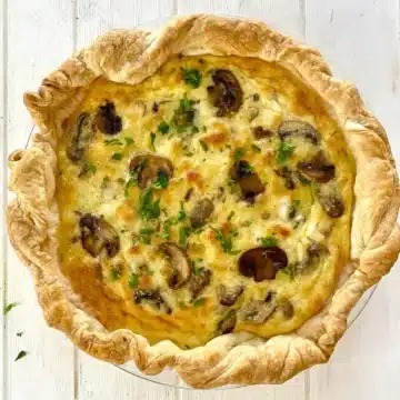 whole mushroom quiche with a puff pastry crust.