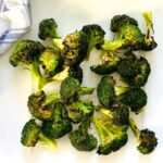 broiled broccoli on a white platter.