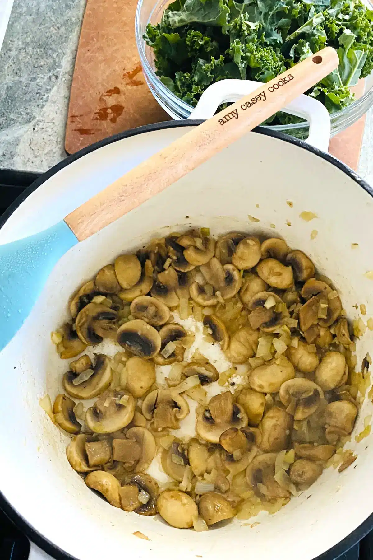 sauteed mushrooms, onions, and garlic in a white Dutch oven.