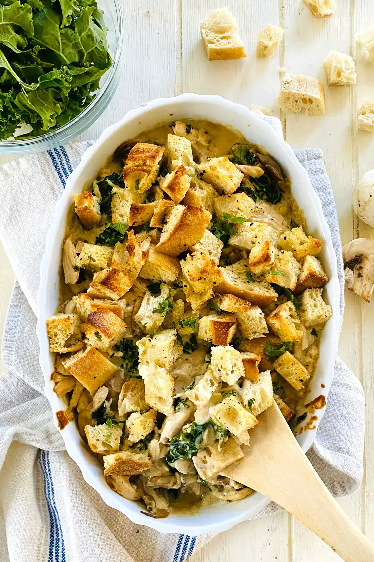 chicken and kale casserole with a wooden spoon.