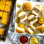 A platter of cheeseburger sliders with ketchup and mustard.
