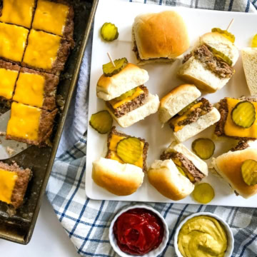 A platter of cheeseburger sliders with ketchup and mustard.