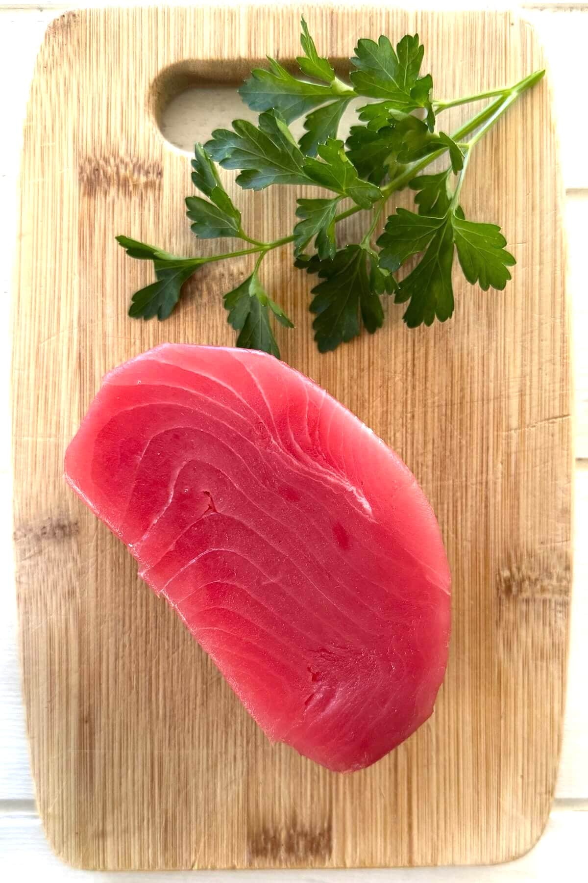 A tuna steak on a cutting board.