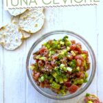 A bowl of ceviche with pepper water crackers.