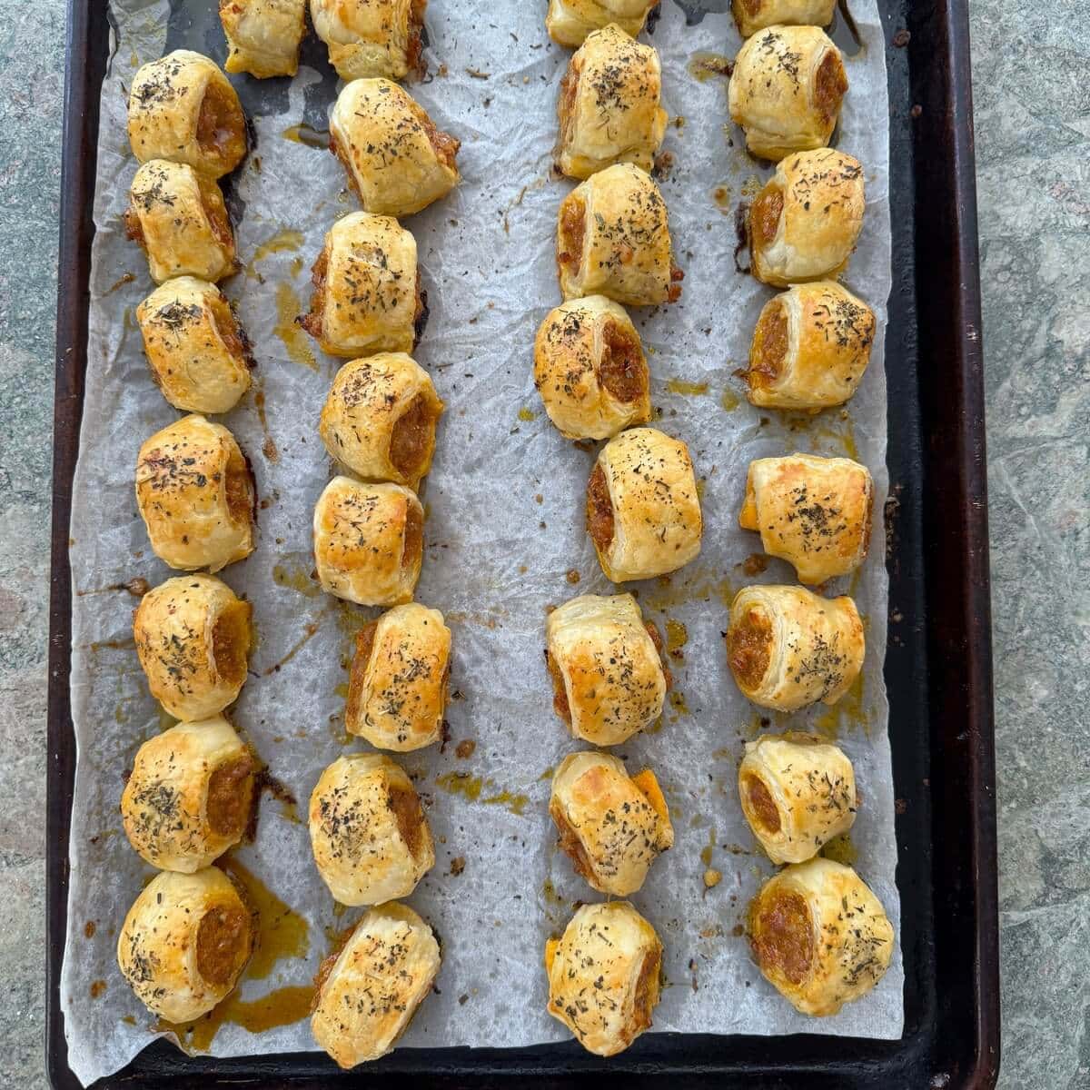 Baked sausage rolls on a pan.