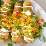 Baked rolled tacos on a platter.