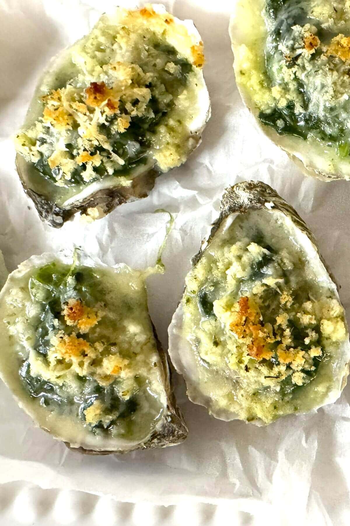 4 baked oysters Rockefeller style on a plate.