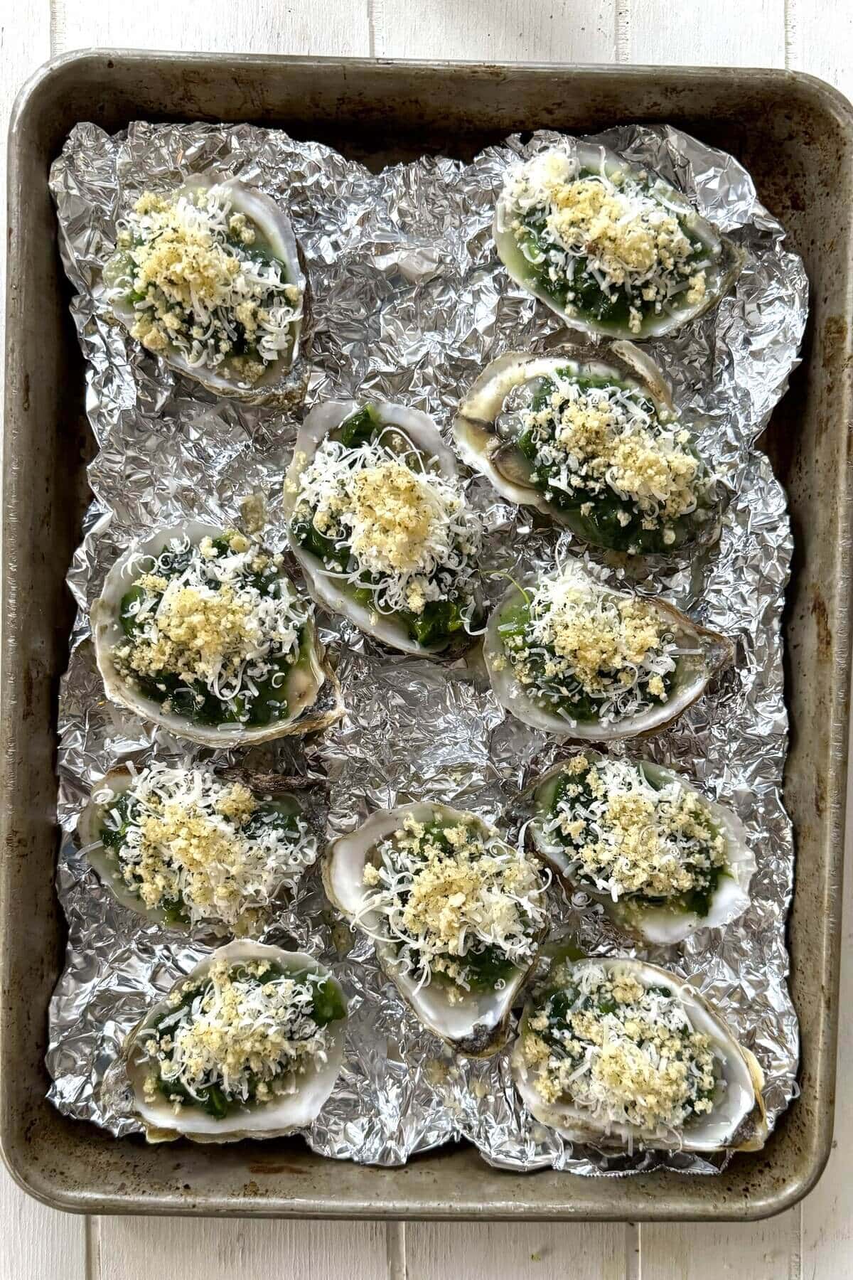 Baked oysters Rockefeller on crumpled foil.