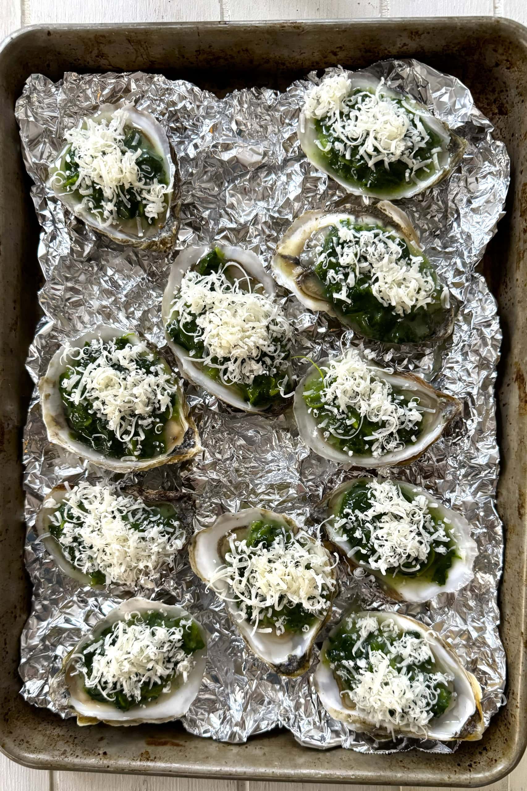 Unbaked oysters Rockefeller topped with parmesan cheese and panko.