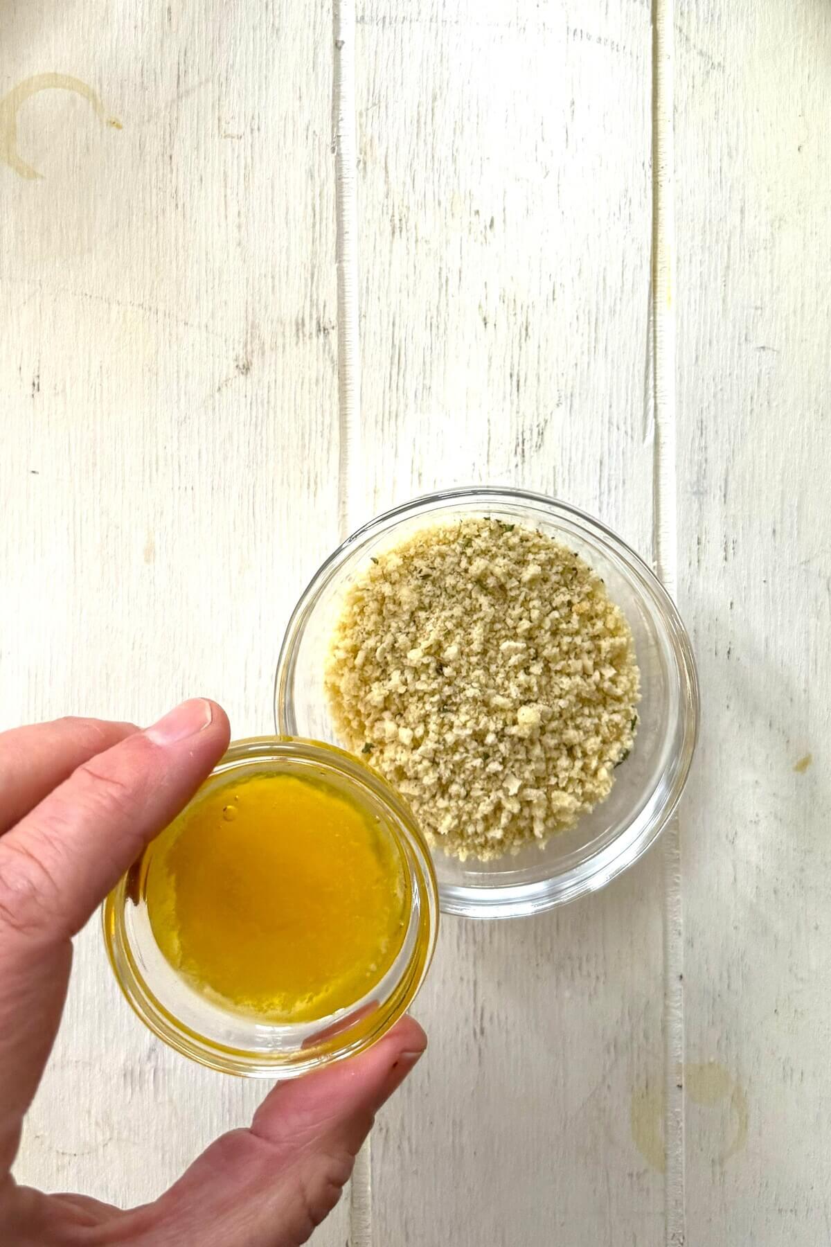 Combining melted butter and panko for Rockefeller oyster recipe.