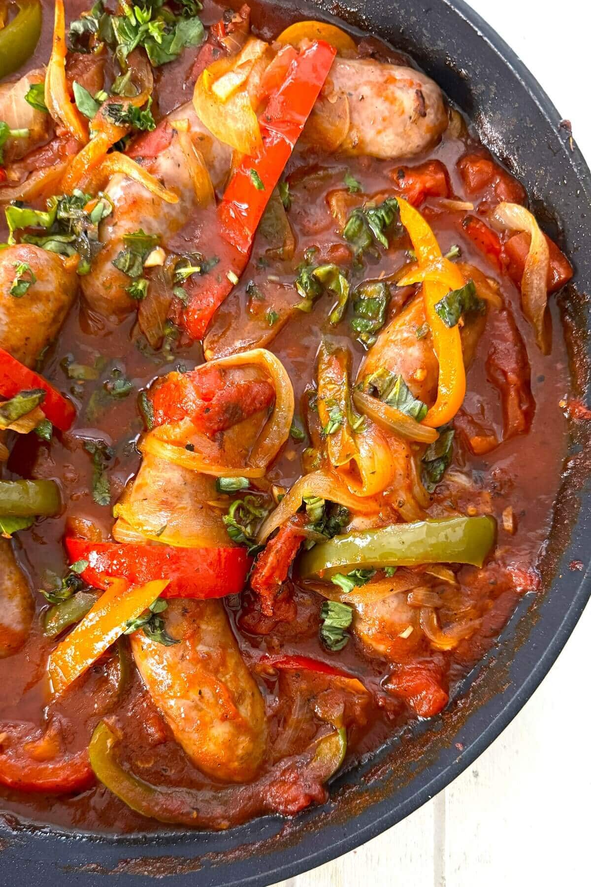 Italian sausage and peppers in a skillet.