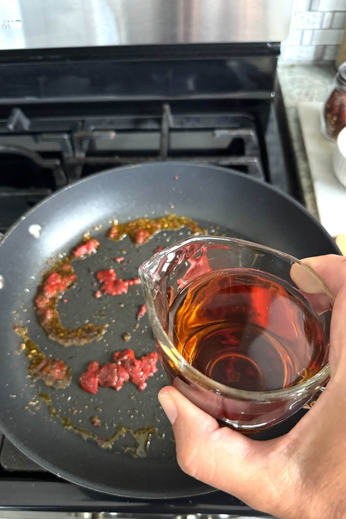 Adding Marsala wine to a skillet.